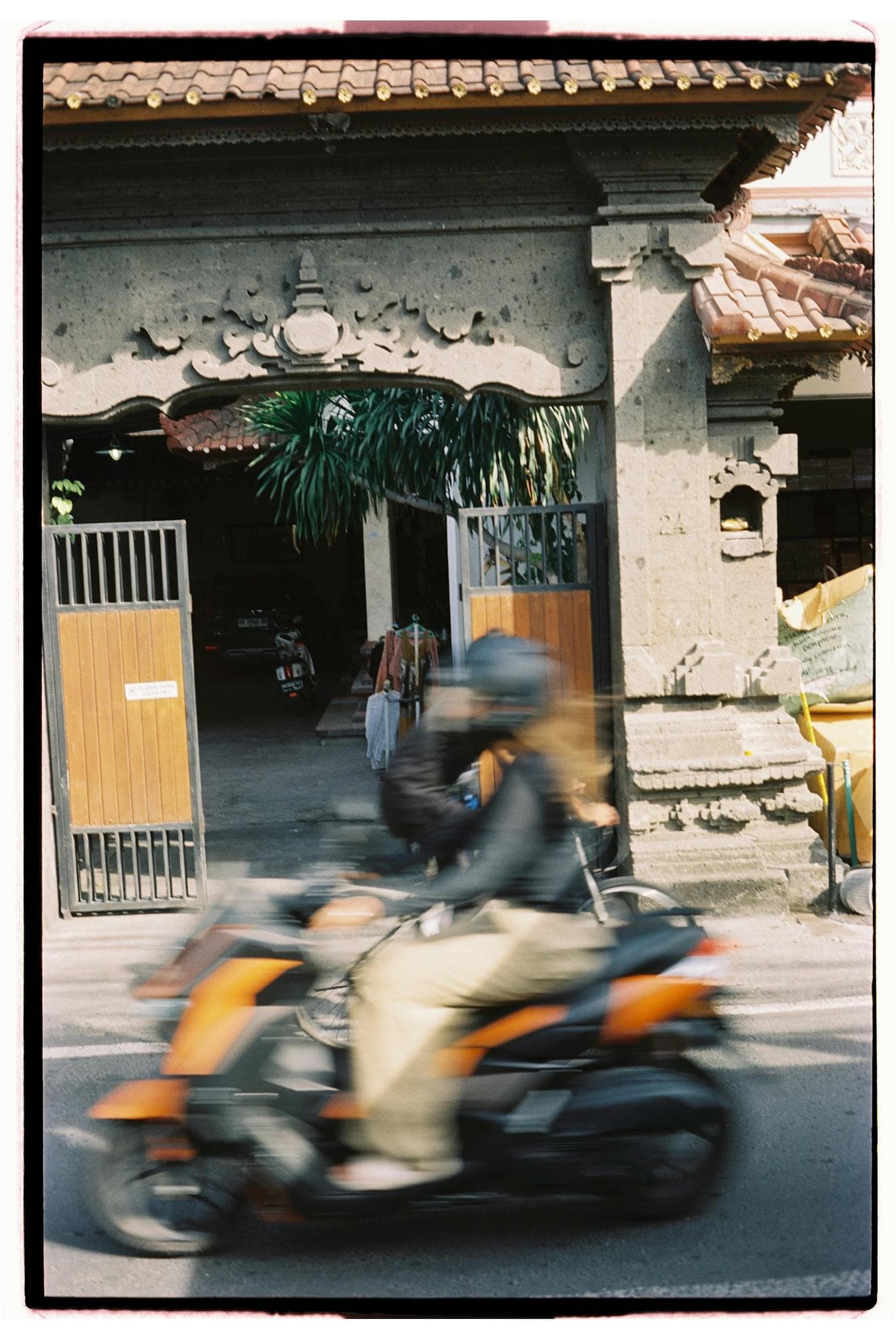 A motorbike moving through Bali streets at night.